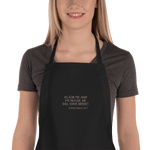 Black apron with embroidered words 'AS FOR ME AND MY HOUSE, WE WILL SERVE BRISKET'.